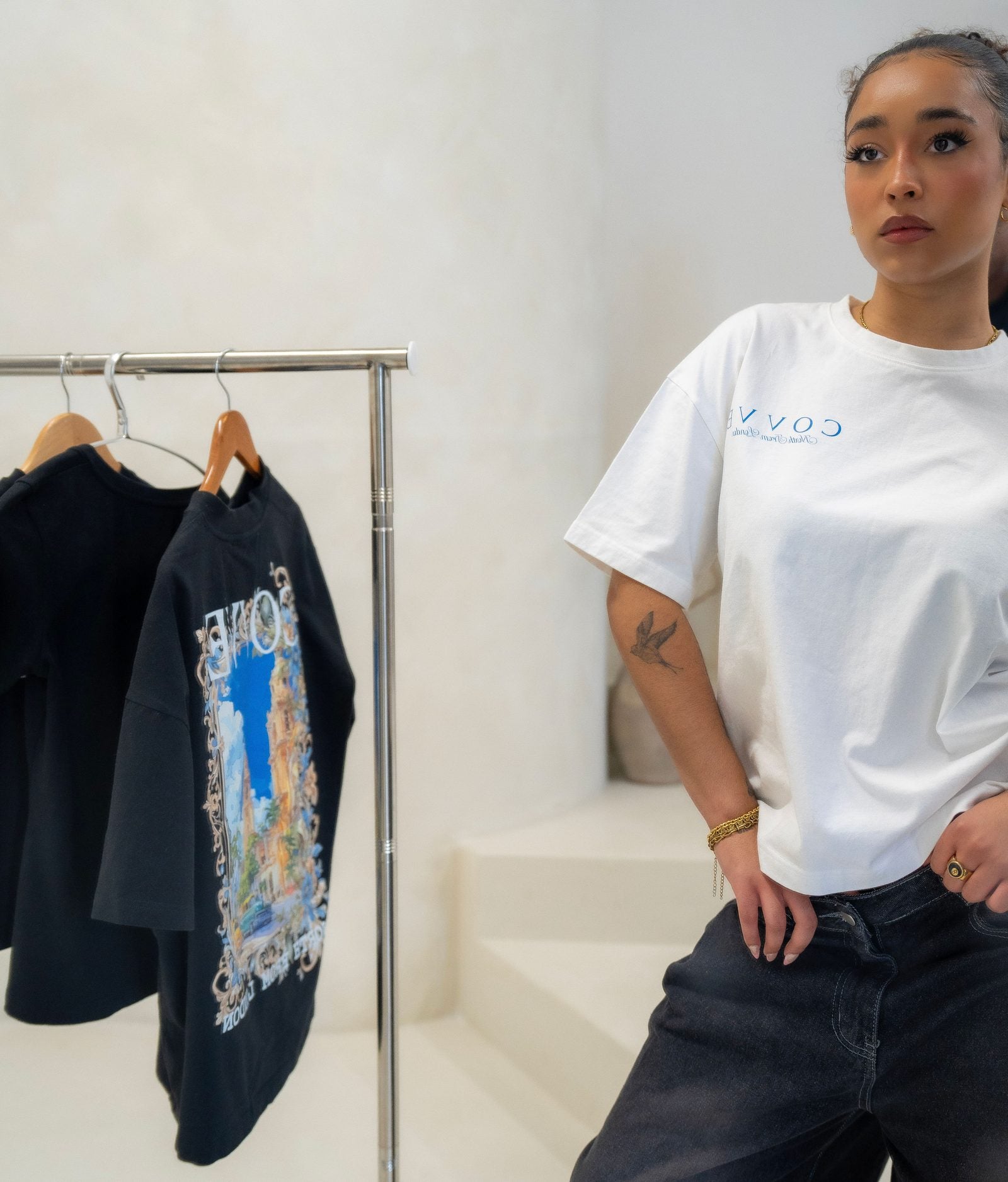 A model in a white COVVE tee beside a rail of North From London pieces