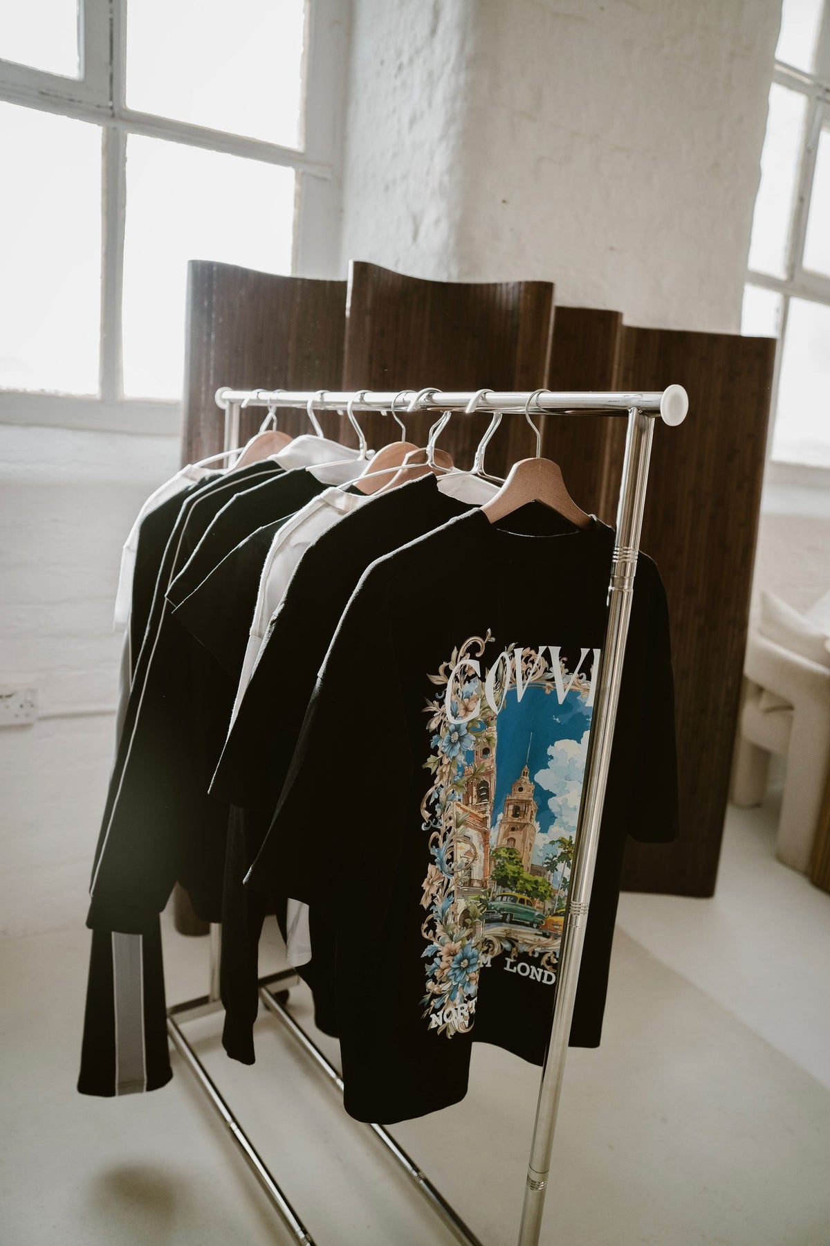 A rail of North From London pieces in the studio, City Bloom tee at the front