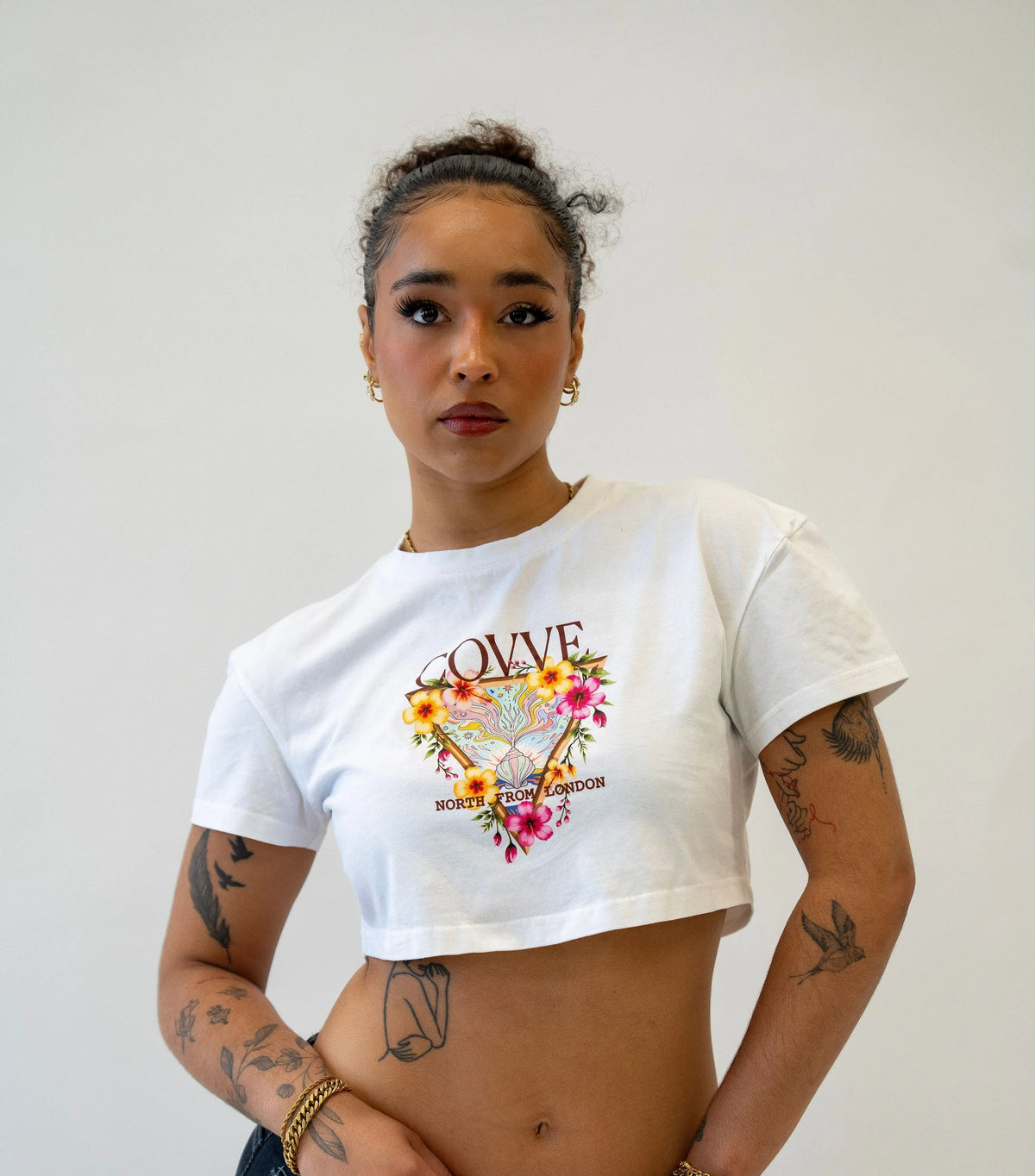 Model wearing a white cropped COVVE North From London T-shirt with a floral triangle print